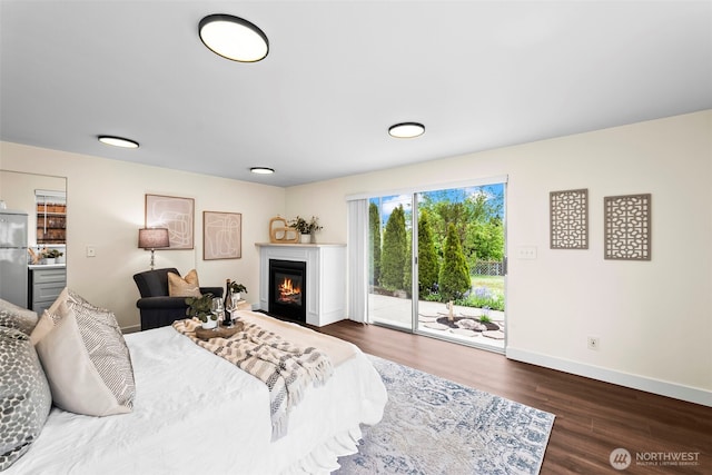 4215 N 27th St, Tacoma, WA 98407 - bedroom featuring a glass covered fireplace, access to exterior, freestanding refrigerator, baseboards, and wood finished floors