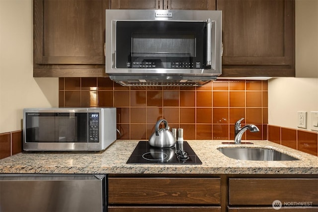 3600 Suncadia Trl Unit 3020, Cle Elum, WA 98922 - kitchen with light stone countertops, dark brown cabinetry, a sink, stainless steel appliances, and decorative backsplash