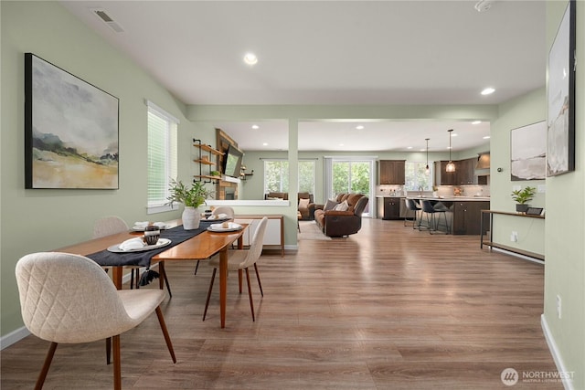 dining room featuring wood finished floors, recessed lighting, and baseboards