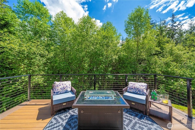 wooden terrace featuring an outdoor living space with a fire pit