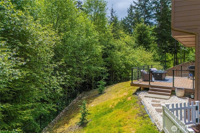 view of green lawn featuring a wooden deck