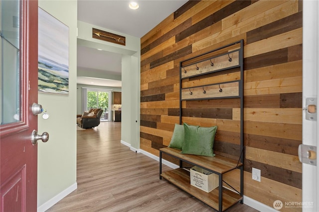 mudroom with wood walls, baseboards, and wood finished floors