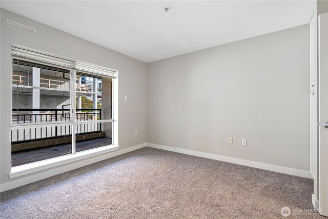 unfurnished room with carpet floors and baseboards