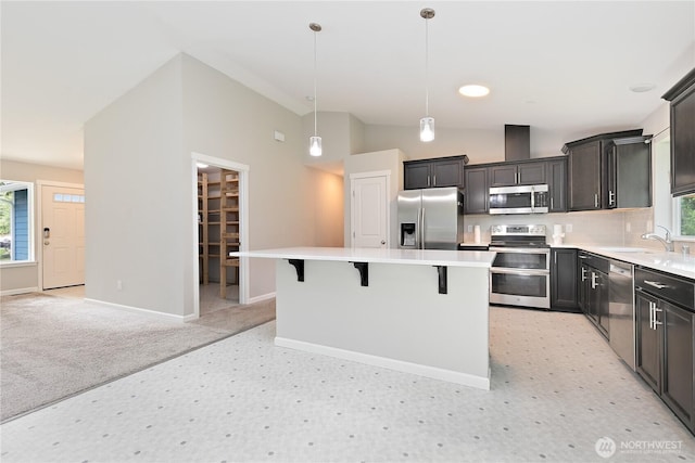 15627 240th St E, Graham, WA 98338 - kitchen featuring appliances with stainless steel finishes, a center island, healthy amount of natural light, baseboards, and lofted ceiling