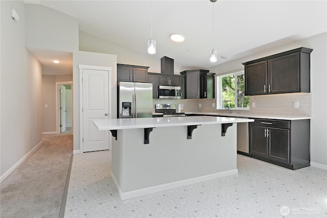 15627 240th St E, Graham, WA 98338 - kitchen with stainless steel appliances, backsplash, light countertops, a kitchen island, and a breakfast bar
