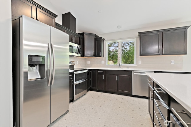 15627 240th St E, Graham, WA 98338 - kitchen with appliances with stainless steel finishes, a sink, decorative backsplash, light countertops, and light floors