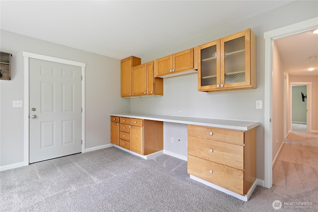 15627 240th St E, Graham, WA 98338 - kitchen with light colored carpet, baseboards, glass insert cabinets, light countertops, and brown cabinets