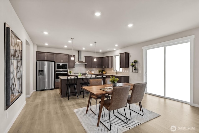 dining area featuring a healthy amount of sunlight, baseboards, recessed lighting, and light wood-style flooring