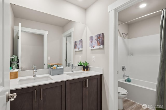 bathroom with a sink, double vanity, toilet, and  shower combination