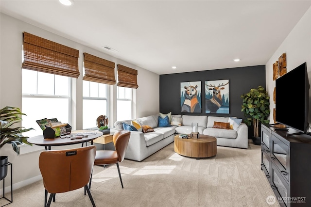 living area with recessed lighting, visible vents, and light carpet