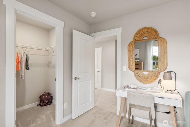 corridor featuring baseboards and light colored carpet