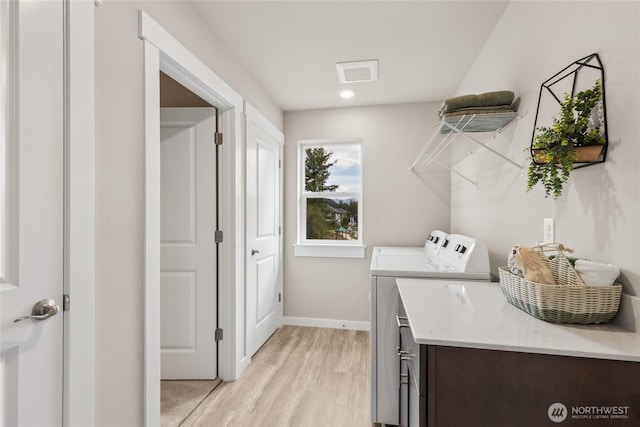 laundry room featuring laundry area, light wood-style floors, baseboards, visible vents, and washer and clothes dryer