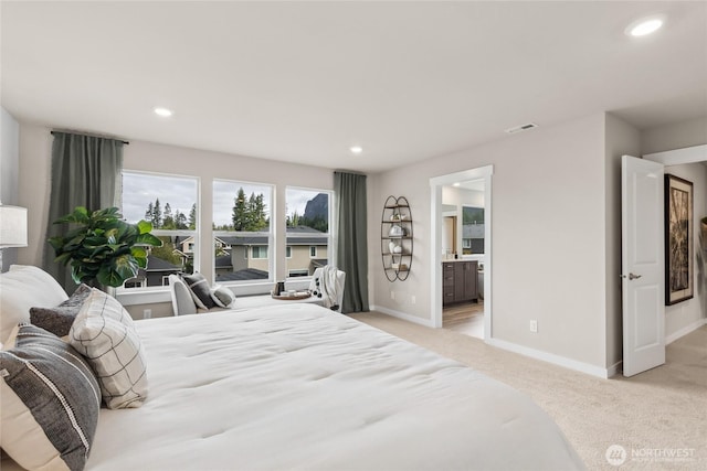 bedroom with baseboards, ensuite bath, visible vents, and light carpet