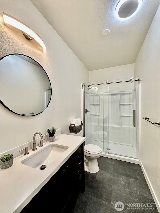 full bathroom featuring vanity, a shower stall, and toilet