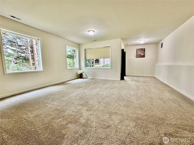 carpeted empty room featuring visible vents and baseboards