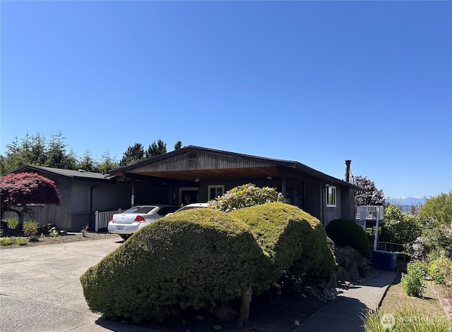 view of home's exterior with concrete driveway and an attached carport