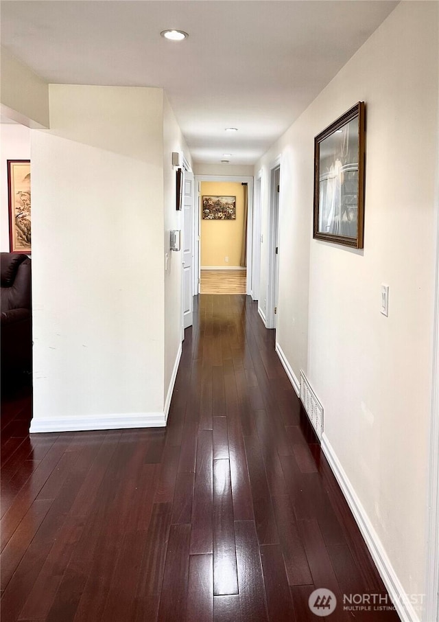 corridor with recessed lighting, baseboards, dark wood-style flooring, and visible vents