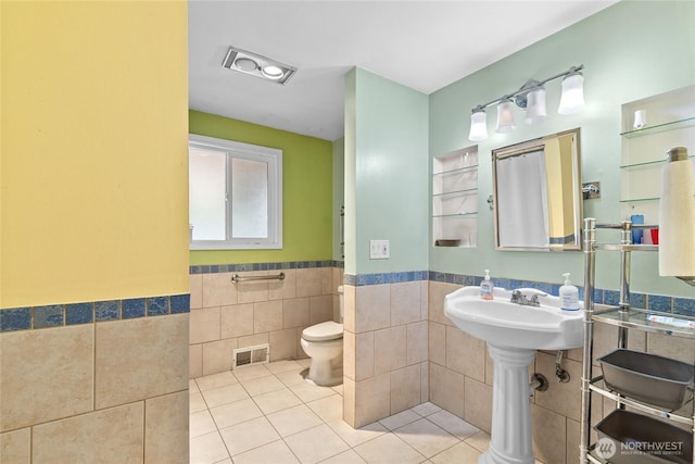 431 12th Pl N, Edmonds, WA 98020 - bathroom featuring tile walls, tile patterned floors, a wainscoted wall, and toilet