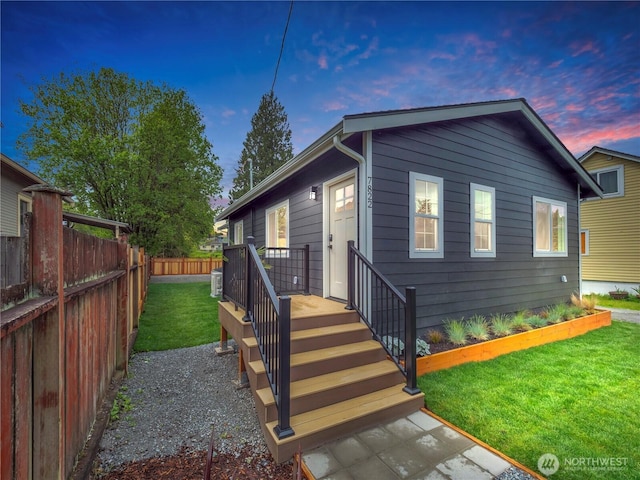 view of front of house with a fenced backyard and a front lawn