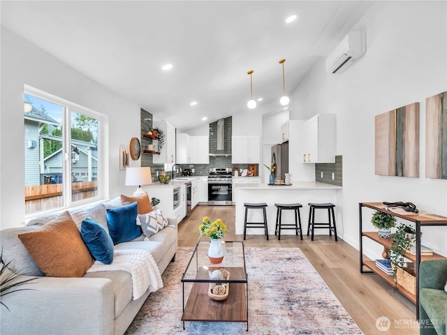 living area featuring an AC wall unit, recessed lighting, light wood finished floors, and lofted ceiling