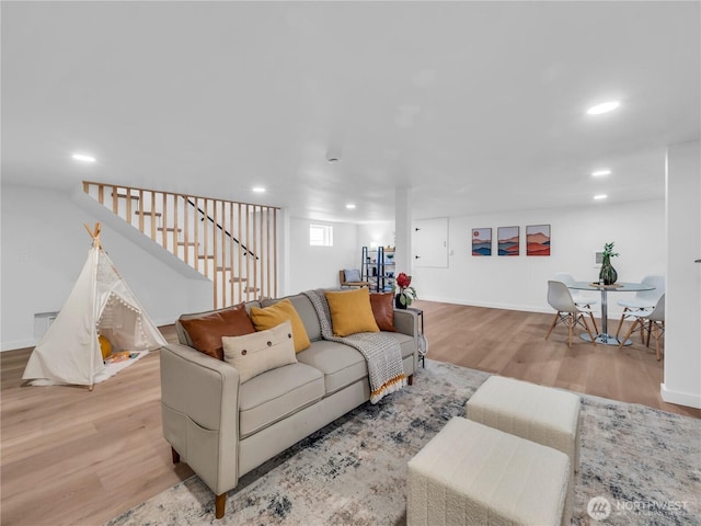 living room featuring recessed lighting, baseboards, stairs, and wood finished floors