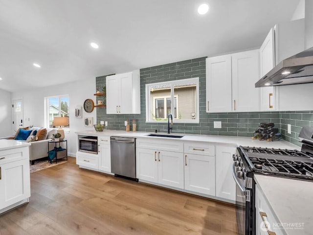 7822 Beverly Blvd Unit B, Everett, WA 98203 - kitchen with stainless steel appliances, a sink, wall chimney exhaust hood, decorative backsplash, and open floor plan