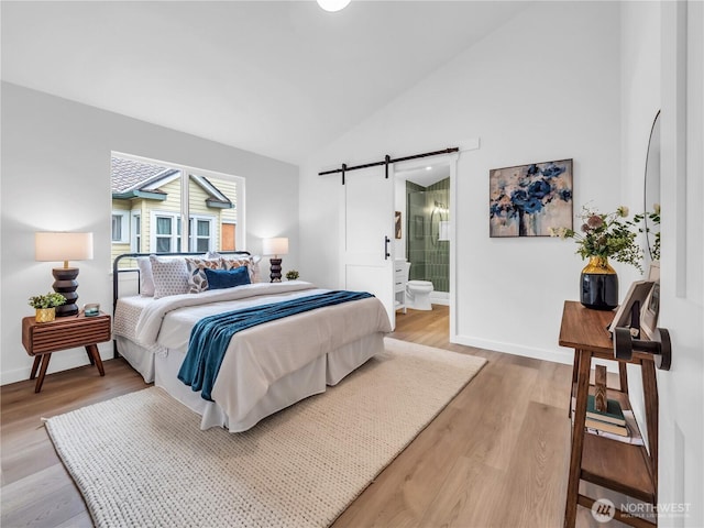 7822 Beverly Blvd Unit B, Everett, WA 98203 - bedroom featuring a barn door, light wood-type flooring, baseboards, high vaulted ceiling, and connected bathroom