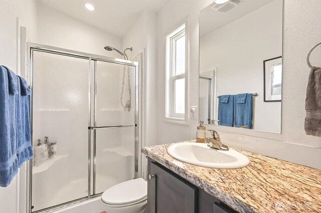 full bathroom featuring toilet, visible vents, plenty of natural light, and a stall shower