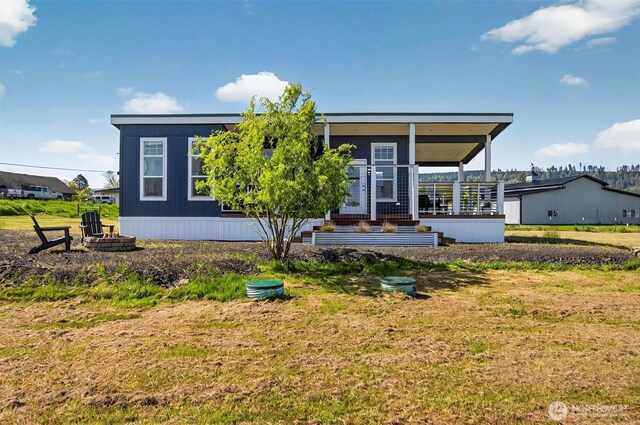 manufactured / mobile home featuring a fire pit and a front yard