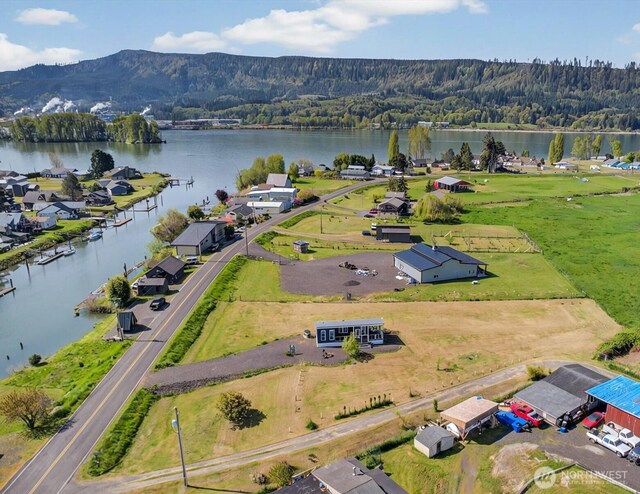 birds eye view of property with a water and mountain view and a wooded view