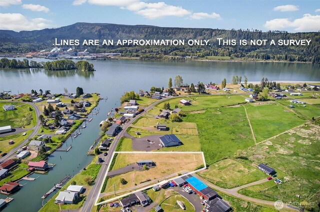 birds eye view of property with a water and mountain view and a forest view