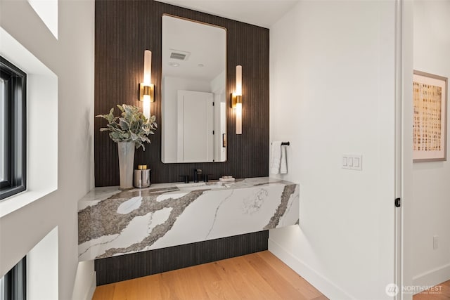 bathroom with baseboards, a sink, and wood finished floors
