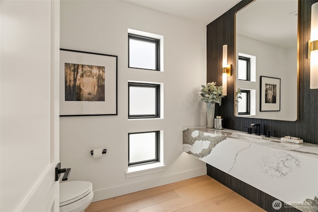bathroom featuring baseboards, toilet, and wood finished floors