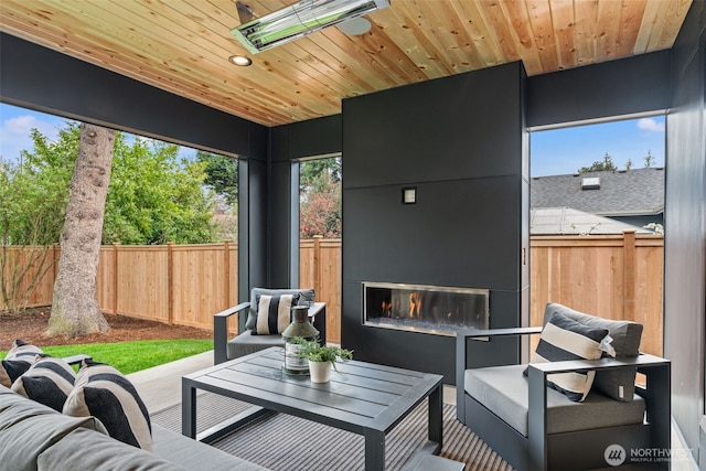 sunroom / solarium featuring an outdoor living space with a fireplace