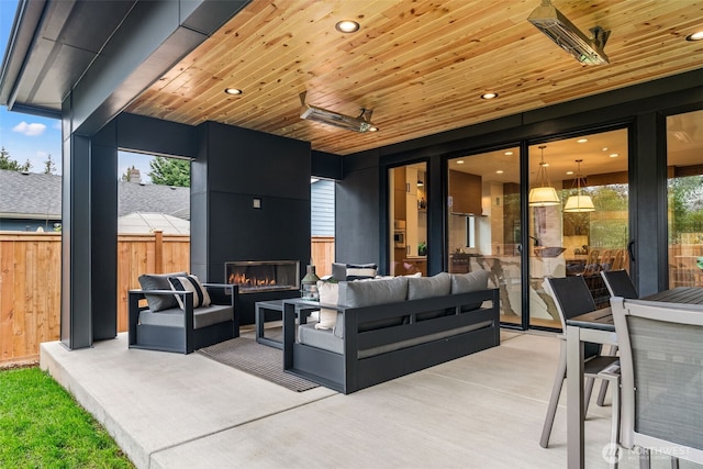 view of patio with fence and an outdoor living space with a fireplace