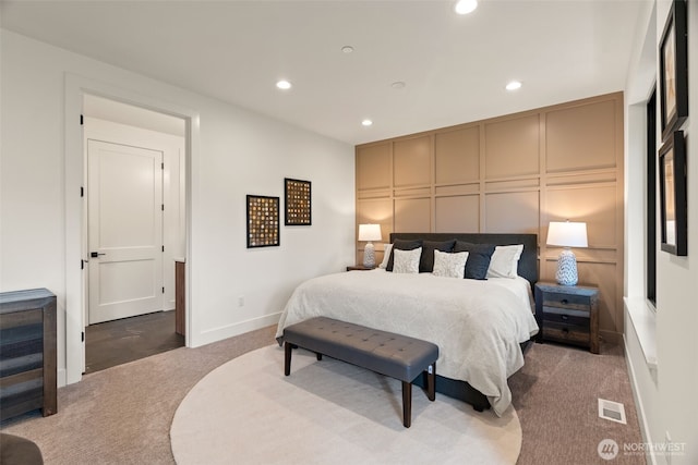 bedroom featuring visible vents, carpet floors, a decorative wall, baseboards, and recessed lighting