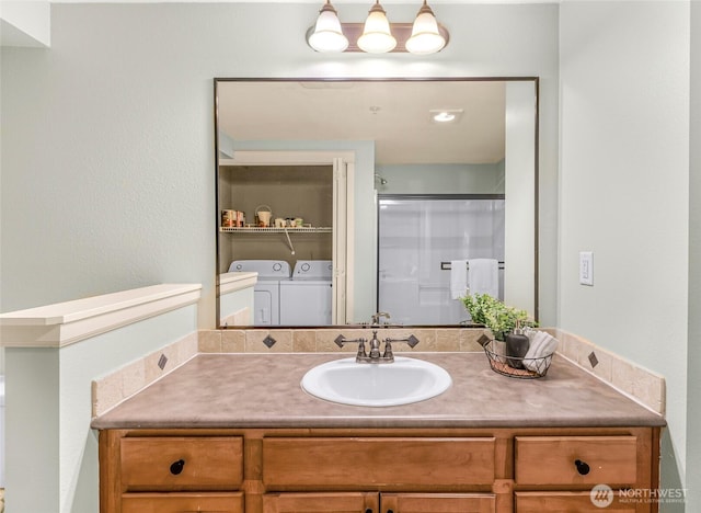 bathroom with independent washer and dryer, a shower stall, and vanity
