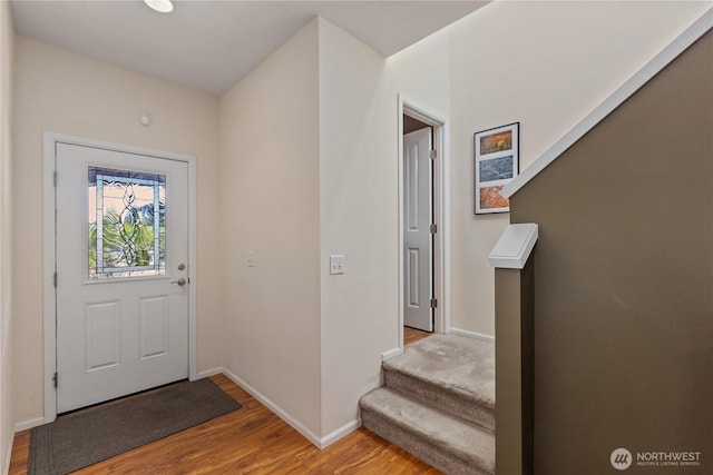 entrance foyer with wood finished floors, baseboards, and stairs