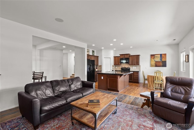living room with wood finished floors, recessed lighting, and baseboards