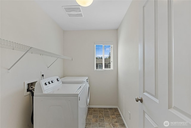 laundry room with washer and dryer, baseboards, and stone finish floors
