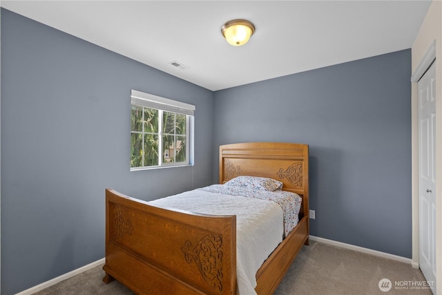 carpeted bedroom featuring baseboards and a closet
