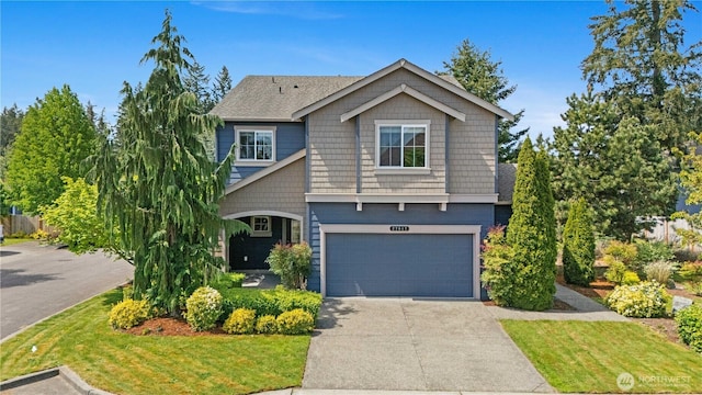 craftsman-style home with concrete driveway, a garage, and a front yard