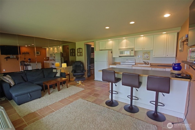 8903 Crescent Bar Rd NW Unit 107, Quincy, WA 98848 - kitchen with a sink, open floor plan, white appliances, and a kitchen bar