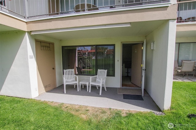 8903 Crescent Bar Rd NW Unit 107, Quincy, WA 98848 - view of exterior entry with a patio area, stucco siding, and a yard