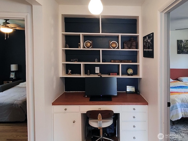 11515 7th Ave NE, Seattle, WA 98125 - office area featuring ceiling fan, built in shelves, built in desk, and wood finished floors