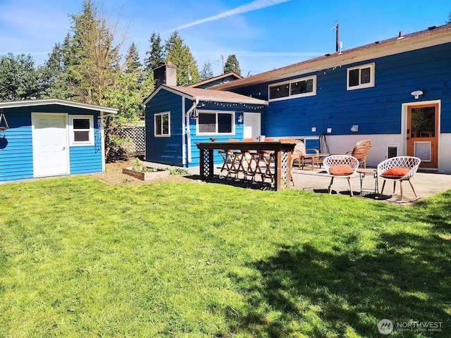 11515 7th Ave NE, Seattle, WA 98125 - rear view of house with an outbuilding, a chimney, a yard, and a patio