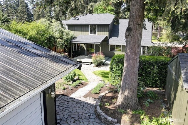 rear view of property with roof with shingles and fence