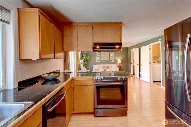 kitchen featuring appliances with stainless steel finishes, under cabinet range hood, light wood-style flooring, tile countertops, and a peninsula