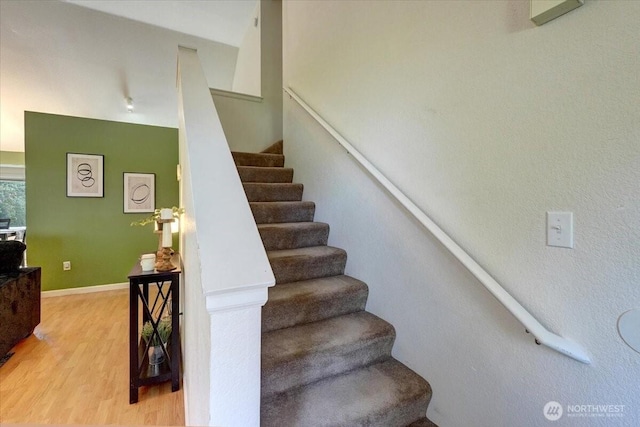 stairway featuring wood finished floors and baseboards