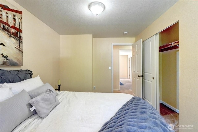 bedroom with carpet floors, baseboards, a closet, and a textured ceiling